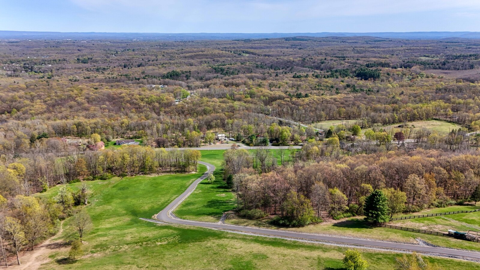 Aerial view of forested and open terrain across the 198-acre estate