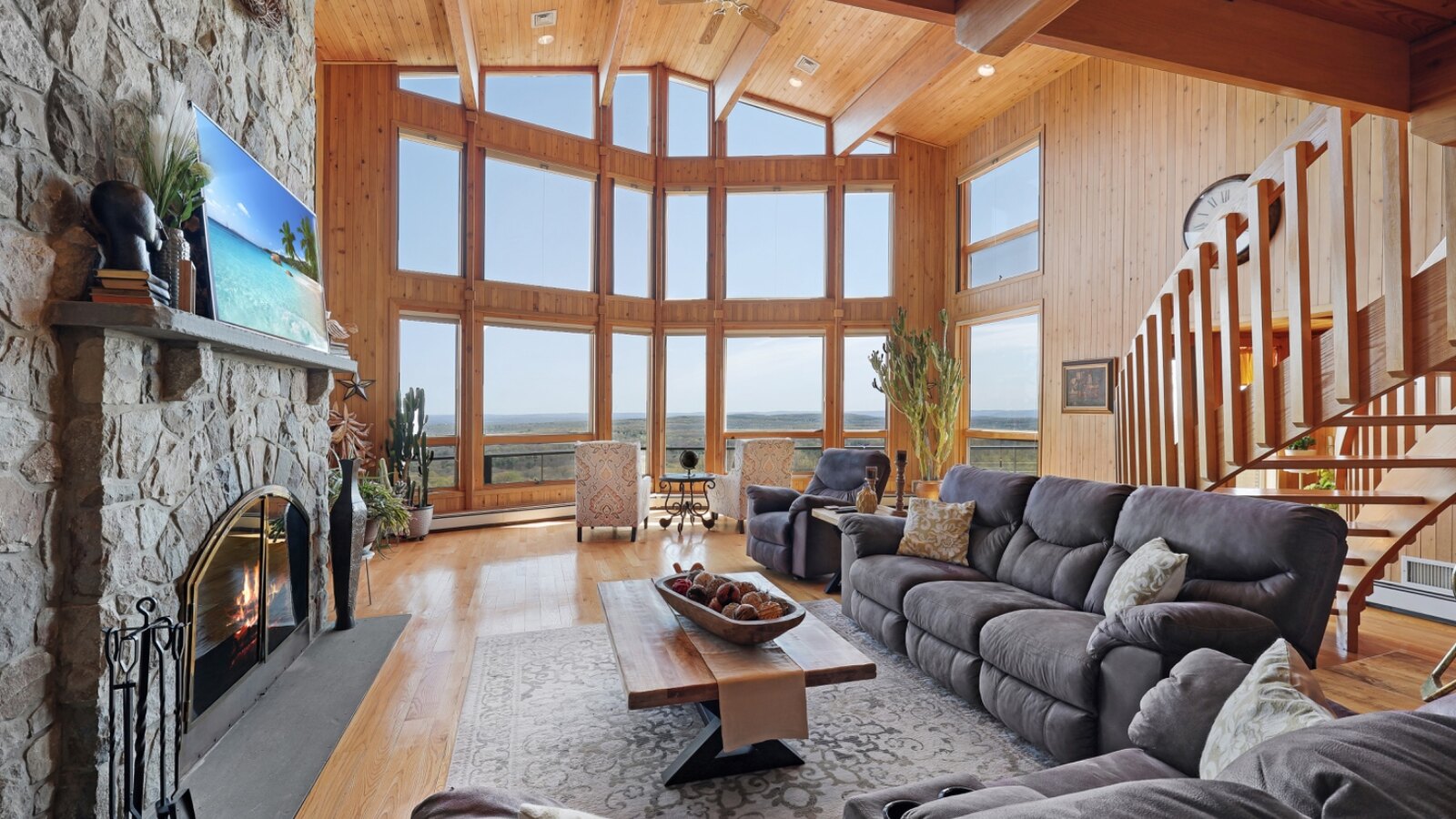 Wood-ceilinged great room with floor-to-ceiling glass framing the valley