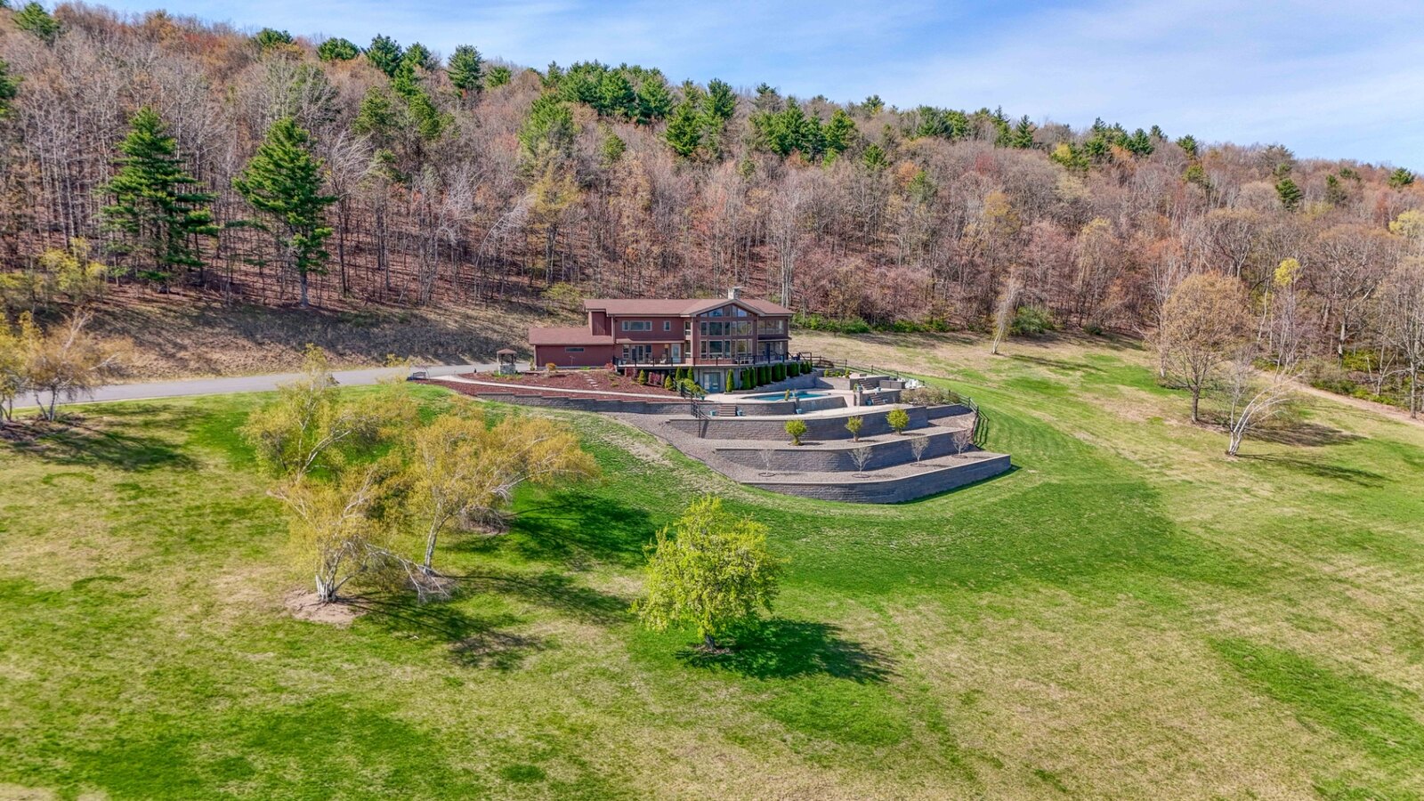 Exterior of the glass-walled mountain home and surrounding trails