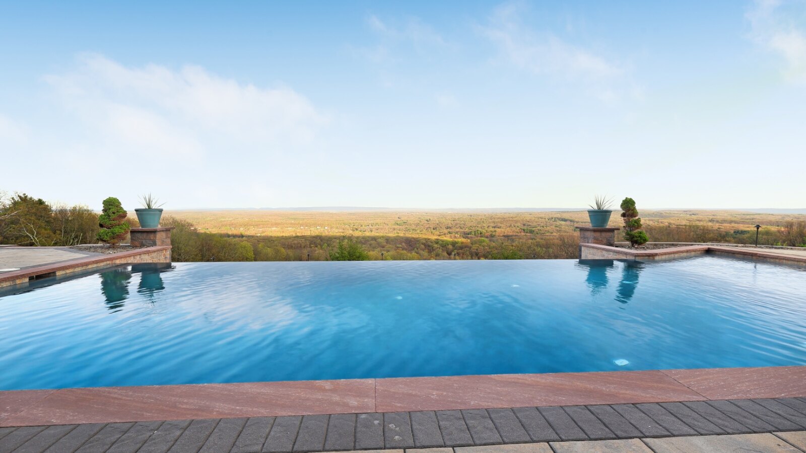 Heated infinity pool spilling toward an endless ridgeline vista at Noble Pine Retreats
